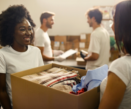 People at a clothing drive accepting a box of donations