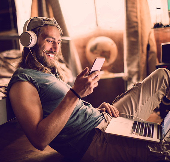 Young man banking from his phone and laptop