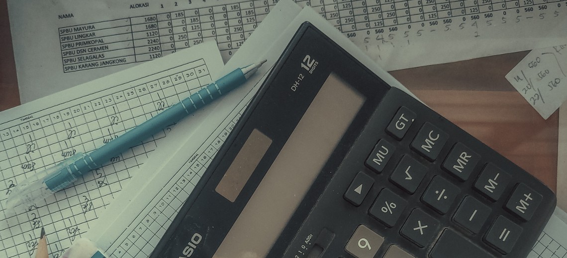 Calculator sitting on a desk with papers